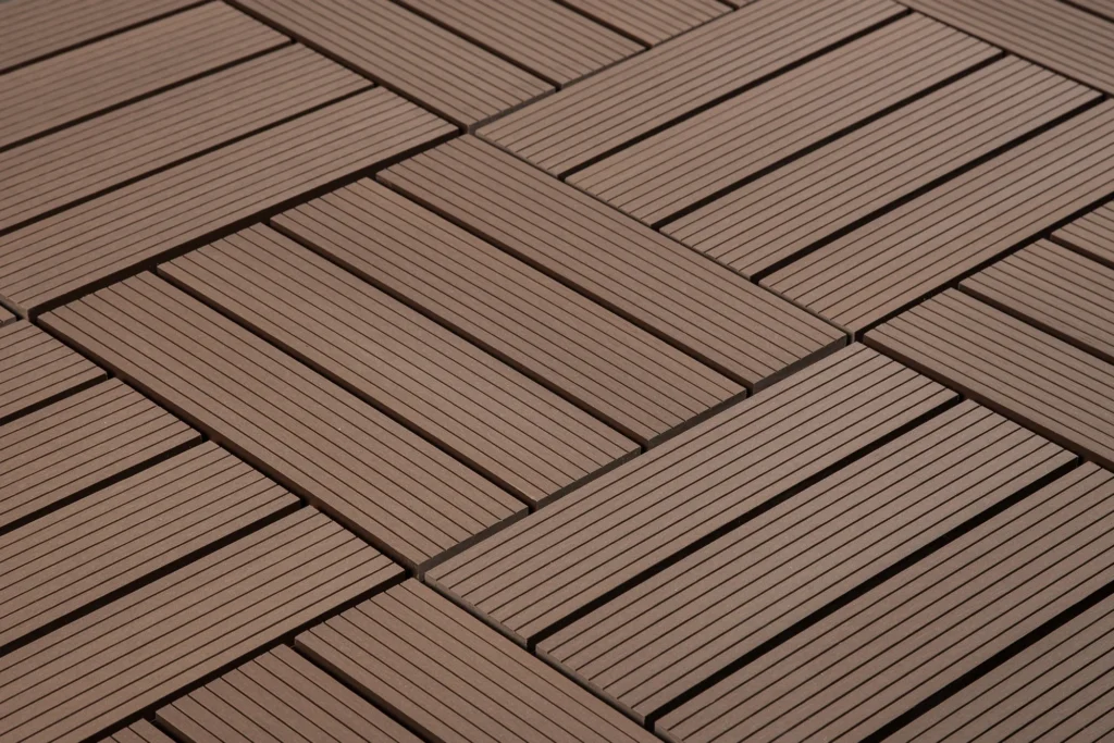 Close-up of interlocking wooden deck tiles arranged in a crisscross pattern.