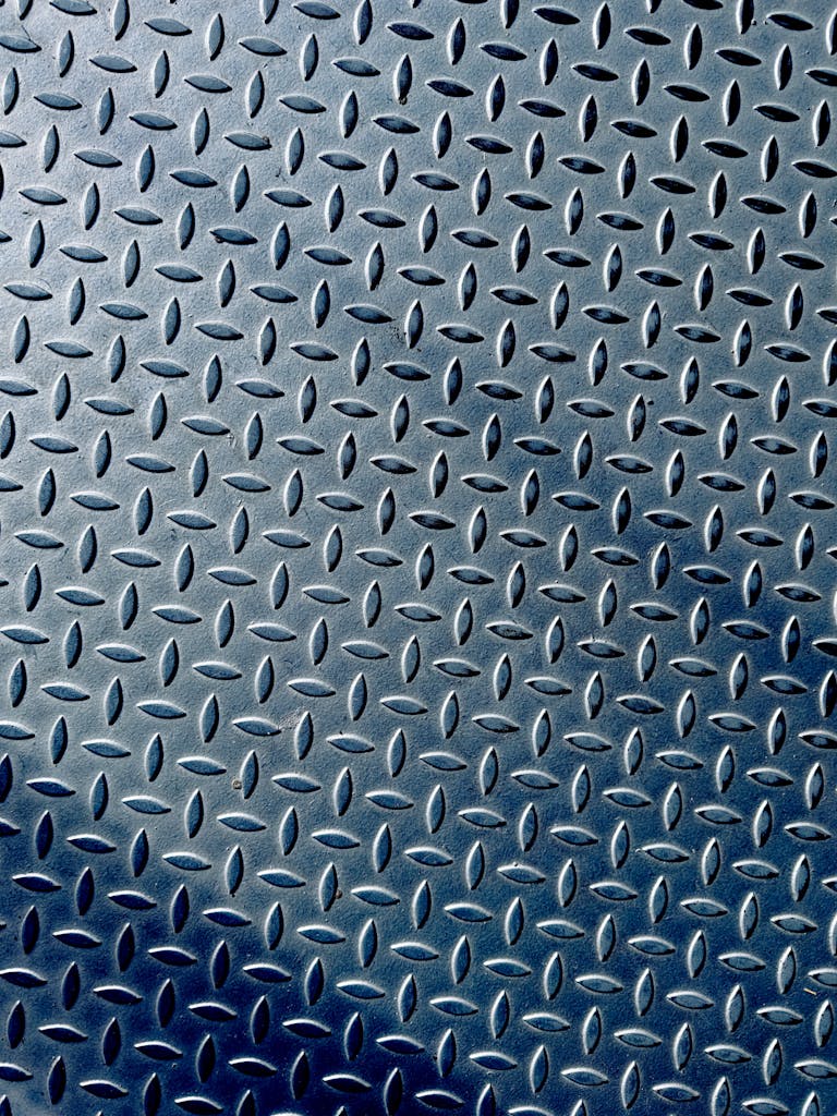 Close-up of a metallic diamond plate with a textured industrial pattern.