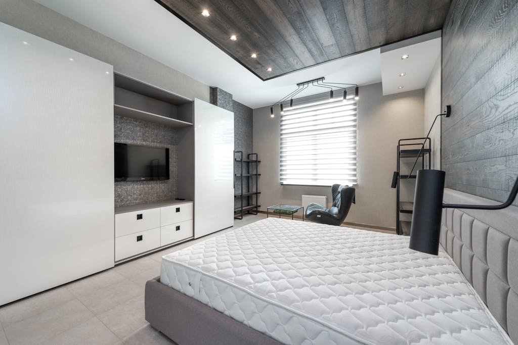 Elegant and spacious modern bedroom with minimalist decor and neutral color palette.