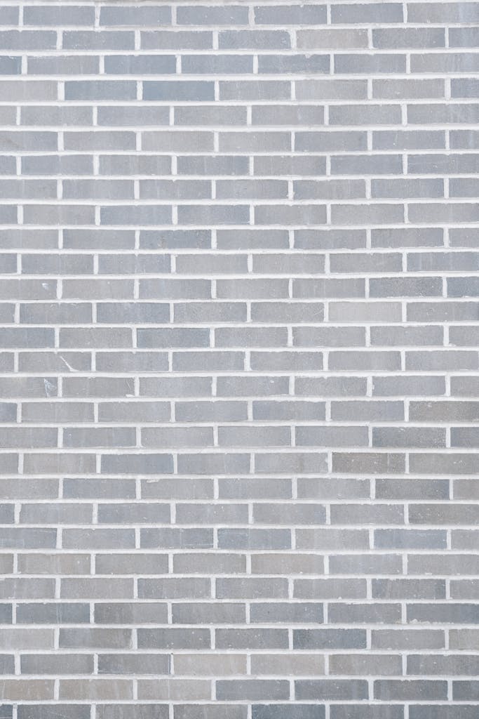 Full frame background of empty gray wall build with rows of brick blocks