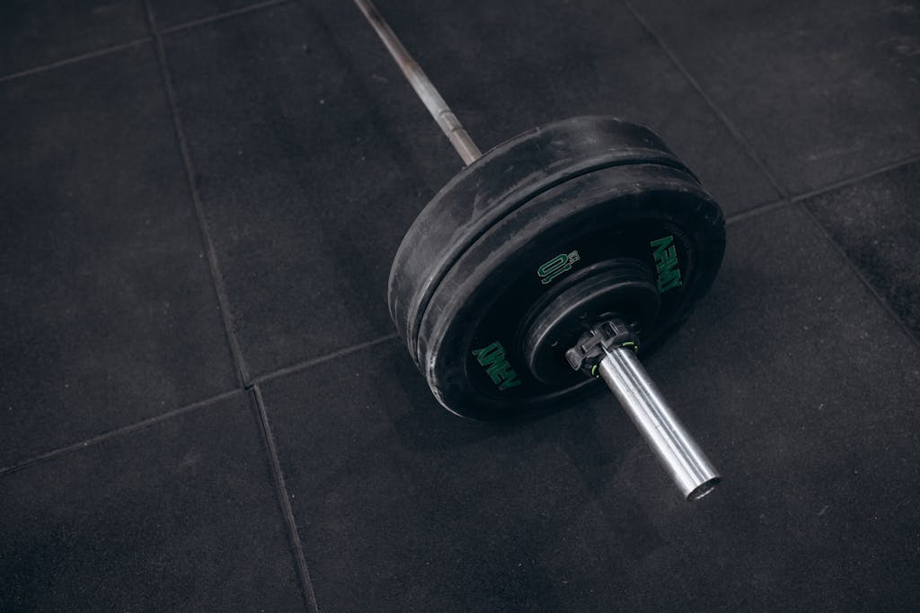 Heavy barbell resting on a gym floor, ideal for strength training visualizations.