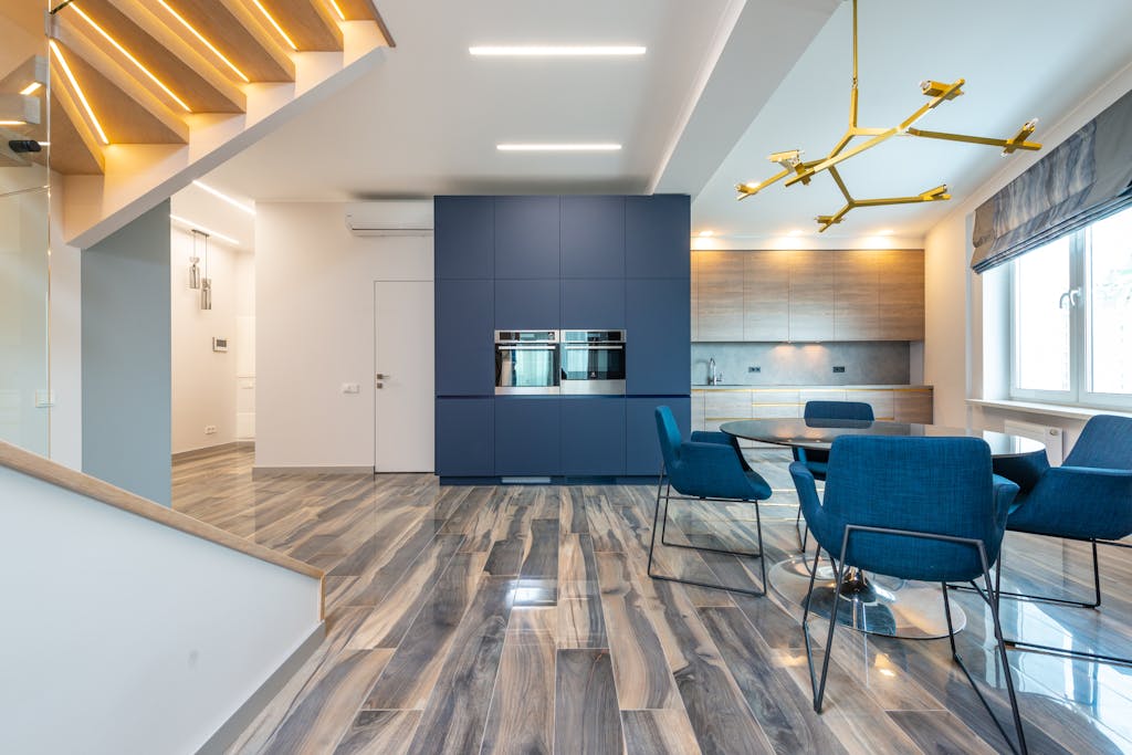 Spacious modern kitchen and dining area with blue accents and stylish furnishings.